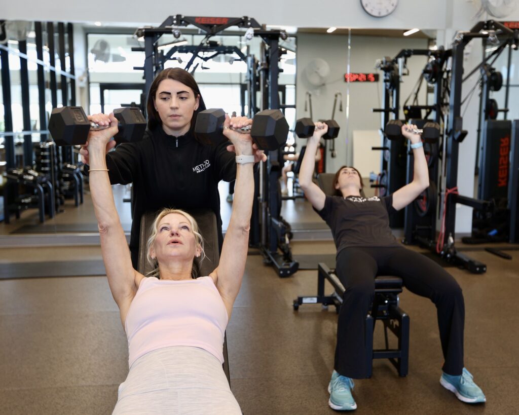 A coach doing functional strength training with a client at Method Health Club.