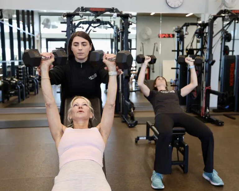 A coach doing functional strength training with a client at Method Health Club.